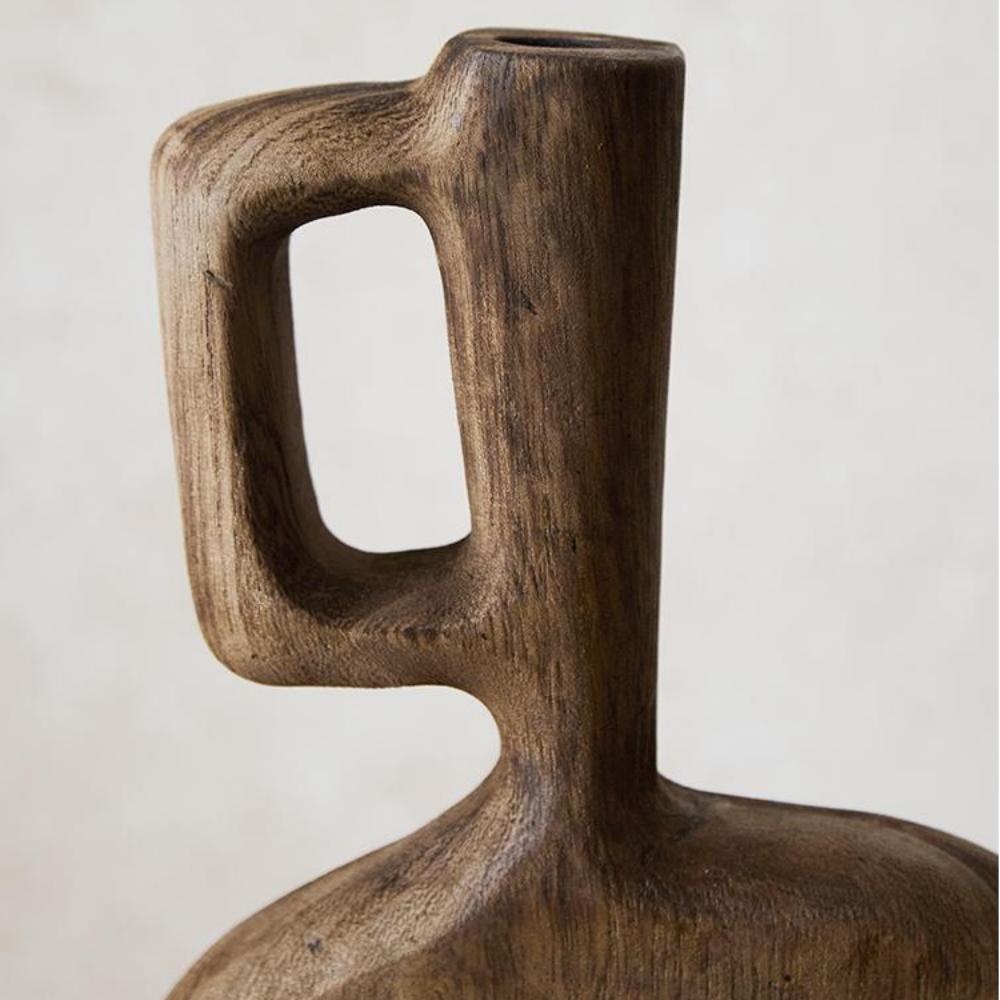 A close-up of the Tall Solid Wood Vase (8×2.4×12.6 in) for living rooms, featuring a rectangular handle, rounded body, and natural wood grain texture set against a neutral background.