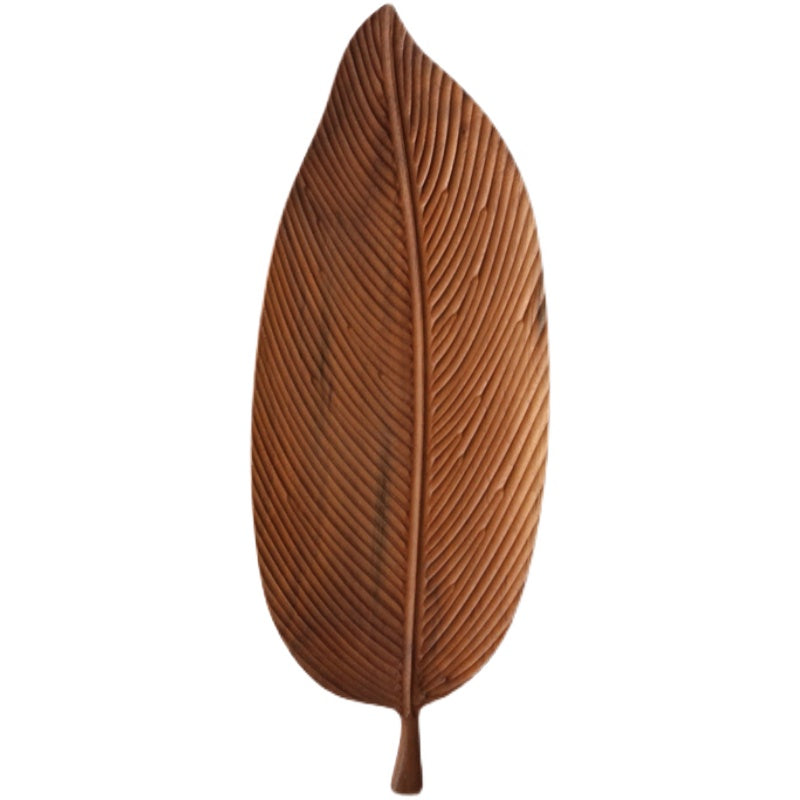 The Leaf-Shaped Black Walnut/Rubberwood Serving Tray, featuring carved veins and a smooth finish inspired by Japanese minimalism, is displayed on a white background.